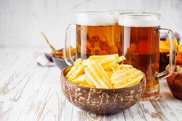 mug of beer and a set of dry fish snacks on a white wooden rustic background