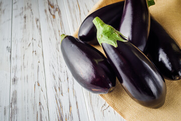 fresh natural eggplant on a light white wooden rustic background