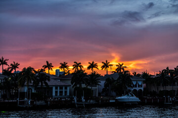 Hollywood Beach in north Miami, Florida Intracoastal water canal Stranahan river and view of waterfront villas houses at beautiful sunset with palm trees in silhouette