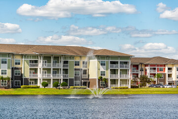 Orlando, Florida luxury lifestyle apartments buildings with three floors by lake water fountain in...