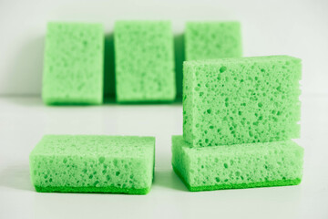 Green sponges for cleaning on a white background