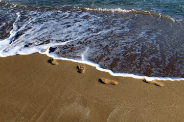Footprints in the sand on the mediterranean sea