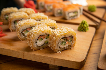 Japanese cuisine. Rolls with sauce on a wooden plate
