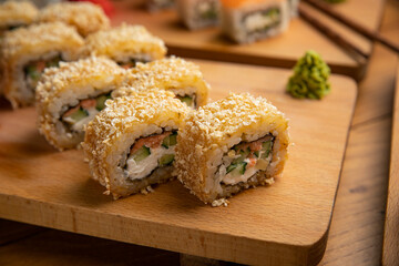 Japanese cuisine. Rolls with sauce on a wooden plate
