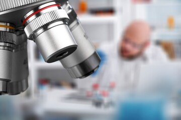 Professional laboratory microscope and scientists working in the background