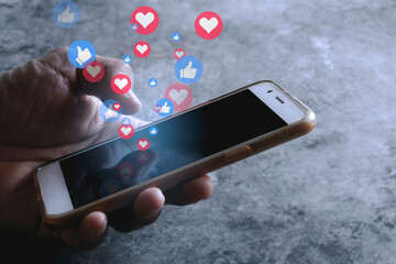 Asia person using a social media put like and love icon chat on mobile phone on black screen of the smartphone. Concept social media internet marketing.