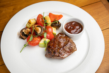 Steak with garnish and sauce on a plate

