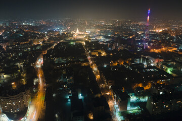 Obraz premium Aerial view of high rise apartment buildings and bright illuminated streets in Ivano-Frankivsk city, Ukraine residential area at night. Dark urban landscape