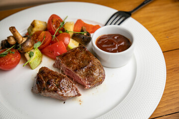 Steak with garnish and sauce on a plate
