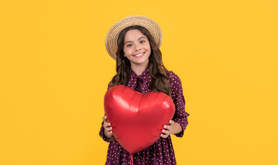 glad teen girl with red heart balloon on yellow background