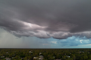 Landscape of dark ominous clouds forming on stormy sky before heavy thunderstorm over rural town...