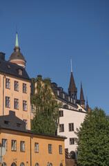 Fototapeta na wymiar Facades, roofs and towers of old 1700s houses at the block Bastugatan in the district Södermalm a sunny summer day in Stockholm