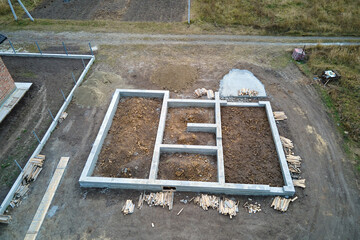Fototapeta premium Top down aerial view of building works of new house concrete foundation on construction site