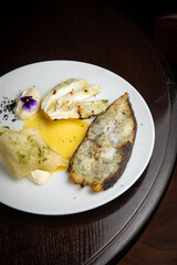 Fish dish with garnish on a plate in a restaurant
