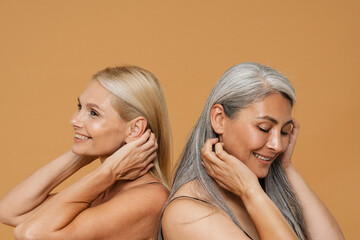 Mature multiracial women wearing bodysuits posing at camera