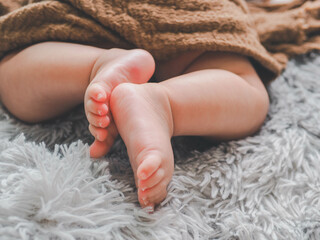 Cute feet of sleeping newborn baby in light bedroom.Top view Baby's legs.