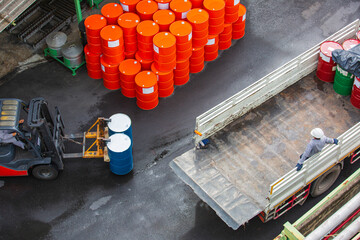 Oil barrels forklift truck move for on the transportation truck male worker arrange.