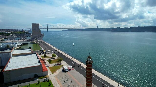 Flying at riverside belem over Belem lighthouse towards Tejo river with 25 abril bridge as background