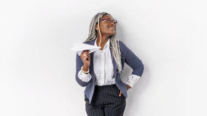 Young beautiful african woman holding hand model paper air plane. Design of travel concept with air plane on empty gray color background