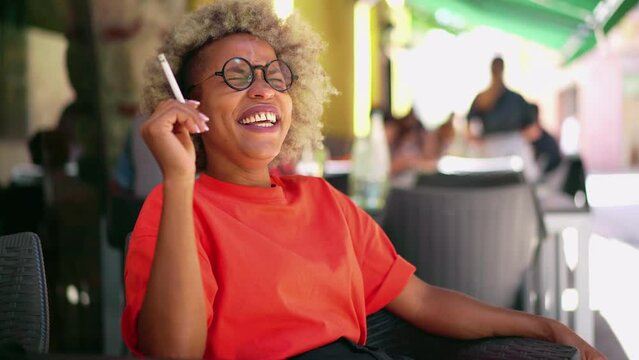 l women is smoking cigarette or tobacco at outdoor cafe