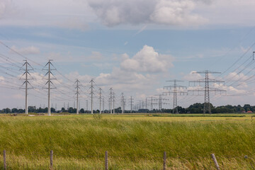 Fototapeta premium Expansion of the high-voltage grid with many high-voltage pylons to meet the growing demand for electricity, photo taken in the province of Groningen, the Netherlands