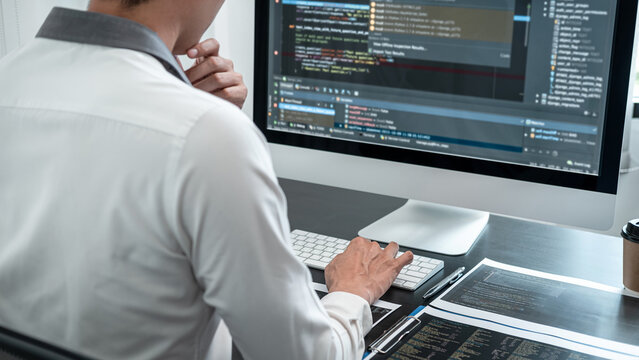 Male programmer working on website project in software development on the desktop computer and making coding and typing data code password security