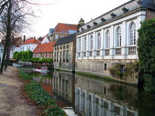 Brugge, Bruges typical street in the old town, old houses with tiled roofs, canal, autumn, Belgium.