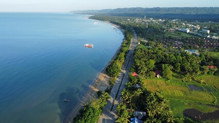 Aerial drone shot of the Bayawan City boulevard and blue ocean, the Philippines