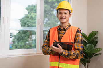 Asian inspector checking structure of new property and taking note in the clipboard for review and fix the house before sell to client