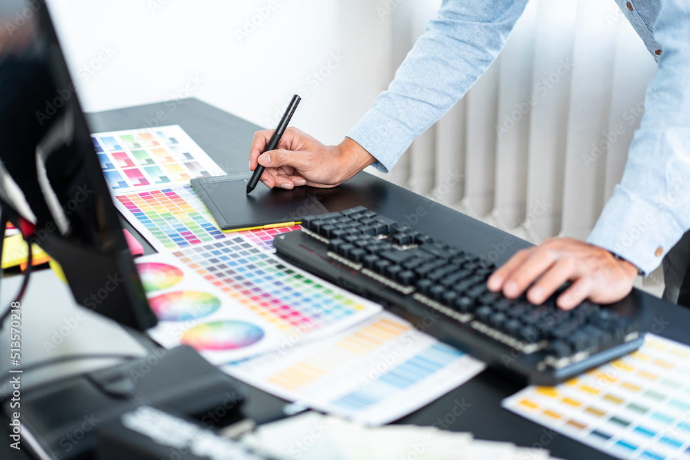 Poster Young creative graphic designer working on color selection and drawing on graphics tablet at workplace, Color swatch samples chart for selection coloring in inspiration to create new collection