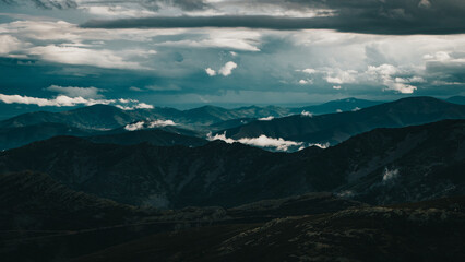 Fototapeta premium Cloudy mountain scenery with blue tones