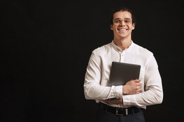 Young handsome smiling man in shirt and glasses holding laptop