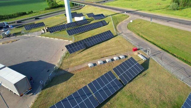 Renewable energy, sustainable development, environment friendly concept. Wonderful green landscape with spinning wind generators on the field with country roads. Beautiful white wind turbine on scenic