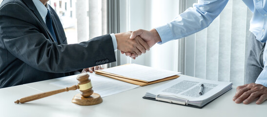 Professional lawyer shaking hands congratulation with a businessman after discussing a good deal of...