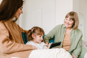 White girl using tablet computer while spending time with her family