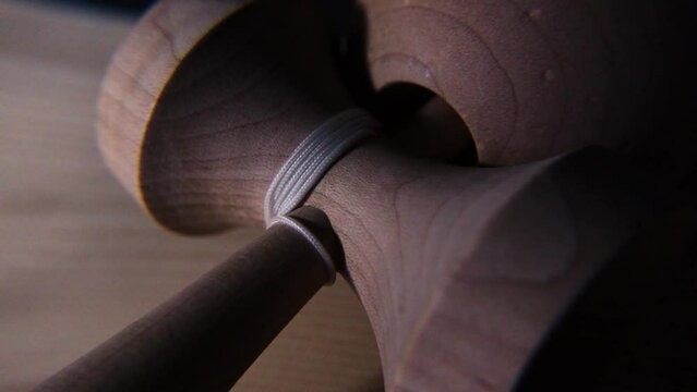 Wooden kendama striped ball on spike string wrapped close up grain