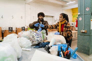 Indian man and woman sorting waste at garbage recycling station
