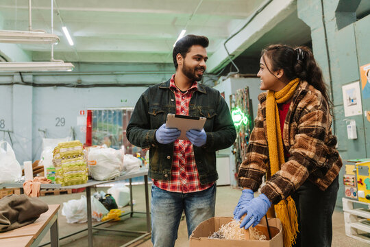 Indian Man With Tablet And Woman Working At Recycling Station