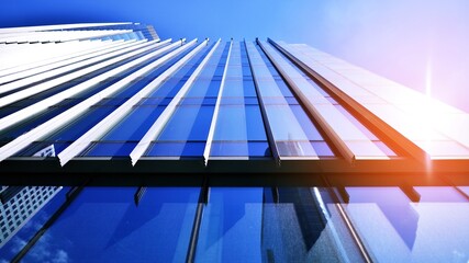 Blue sky reflection in glass facade of building. View of office building windows close up with...