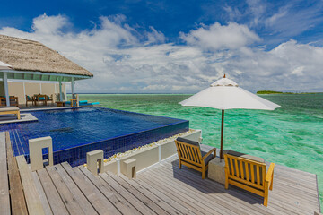 Fantastic over water villa, terrace view with sun beds chairs under umbrella, luxury pool hotel...