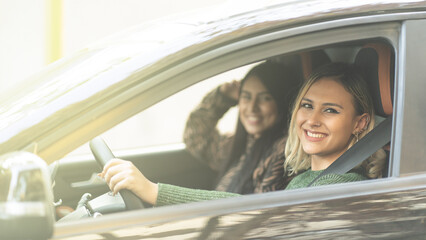Two Young women smiling in a car enjoying a road tripping concept best Friends forever