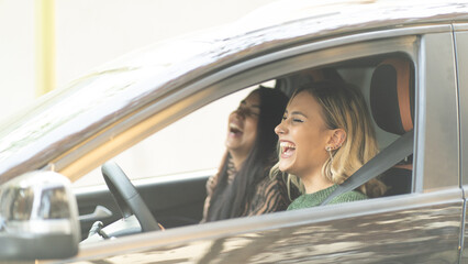 Two Young women smiling in a car enjoying a road tripping concept best Friends forever