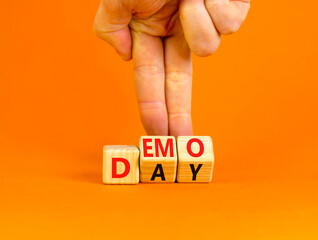 Demo day symbol. Concept words Demo day on wooden cubes. Businessman hand. Beautiful orange table orange background. Business and demo day concept. Copy space. - obrazy, fototapety, plakaty
