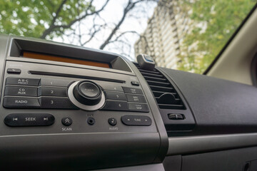 close up of car radio and Cd player console with outside view through windshield