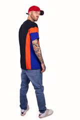 tattooed rap singer posing in studio wearing red cap