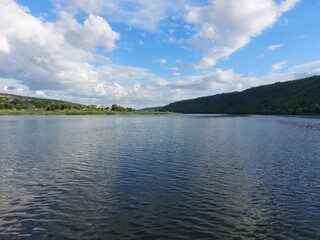 View from the middle of the river to the hilly banks overgrown with forest