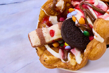 waffle with chocolate, ice cream, strawberry sauce and sweets