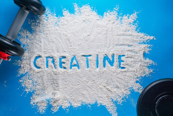 the word creatine written on a white powder. wellness concept.