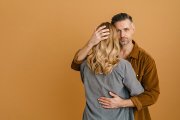 White adult woman and man hugging each other standing isolated