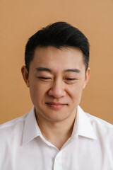 Brunette adult asian man wearing shirt smiling and looking downwards